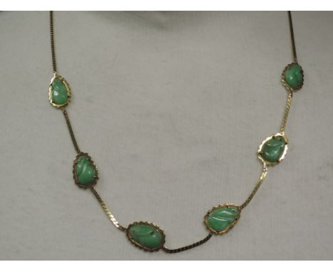 A yellow metal snake chain necklace stamped 585 having six carved jade panels,  approx 15.5g