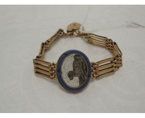 A Victorian yellow metal gate bracelet stamped 9C having a central mosaic panel depicting a dog and a padlock clasp,  approx 