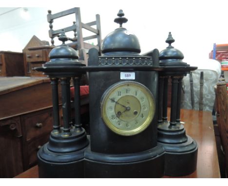 A late Victorian black marble/slate mantel clock of architectural dome design with pillar supports 