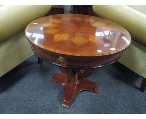 A modern stained frame occasional table having circular lozenge effect top and globe stand base