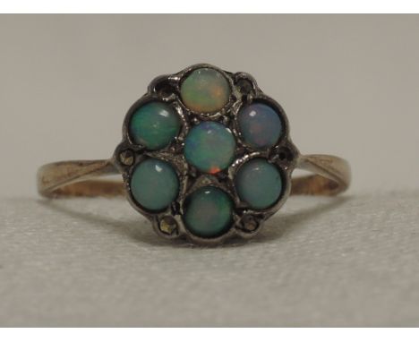 A ladies dress ring having an opal and marcasite cluster on a yellow metal loop stamped 9ct & Silver