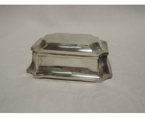 A small silver trinket box of elongated hexagonal form having canted corners and hinged lid with blue velvet lining and leath