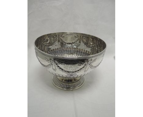 A large Edwardian silver punch bowl having gadrooned decoration to circular pedestal foot and bowl with bow and swag decorati