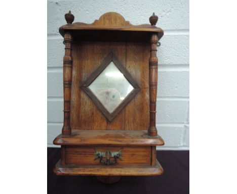 An oak wall bracket having mirror, spindles and drawer, with inscription 'This bracket made from wood, part of St Mary's orga