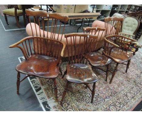 A set of four early 20th century stained beech and elm comb back vernacular chairs having solid seat and crinoline stretchers