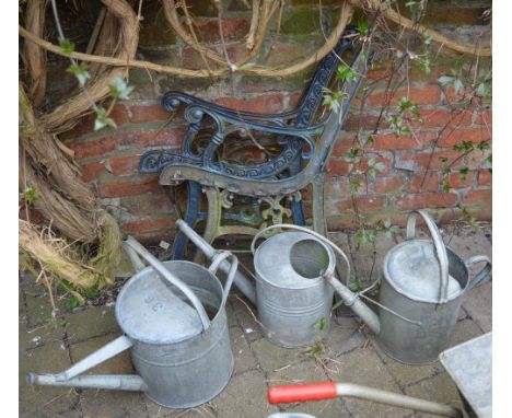 3 galvanized watering cans and a two pairs of garden bench ends