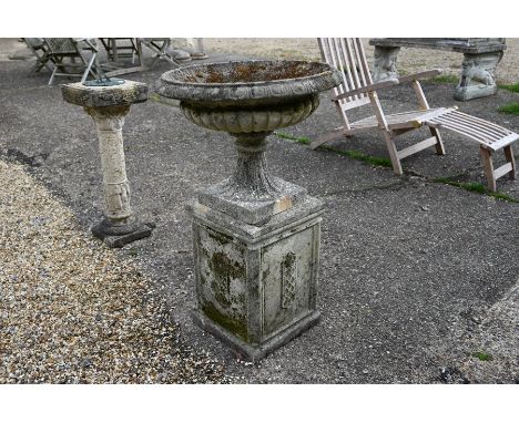 A weathered cast stone garden urn planter on square plinth base to/w another cast stone planter (2)