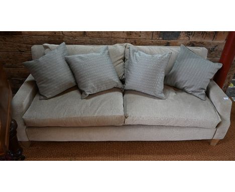 A contemporary two seater sofa with feathered filled cushions in oatmeal fabric upholstery, with straight back and tapered ar