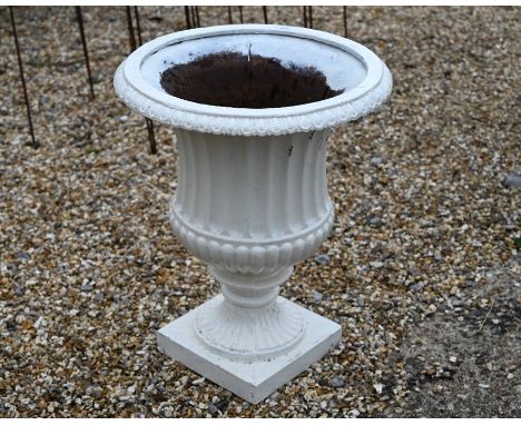 An old cast iron garden urn planter, painted white