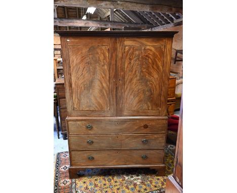A 19th century mahogany linen press with two doors enclosing hanging rail on base with three long drawers, raised on bracket 
