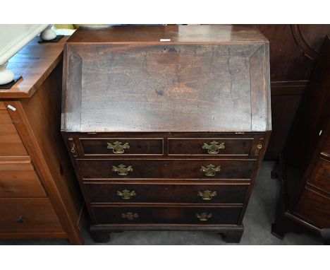 A George III mahogany fall front bureau with fitted interior over two dummy drawers and three graduating drawers with brass s