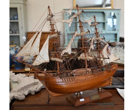 A modern brass skeleton clock in glazed case, 30 cm high to/w a model of HMS Bounty, 49 cm high (2)