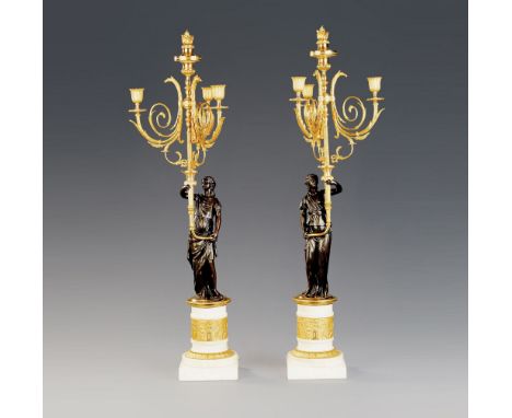 A Pair of French Empire Bronze and Marble Candelabra  each with a standing bronze classical maiden holding aloft a finely cha