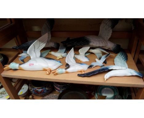 A graduated set of three Poole pottery flying mallard wall plaques; together with seven further gull examples. 