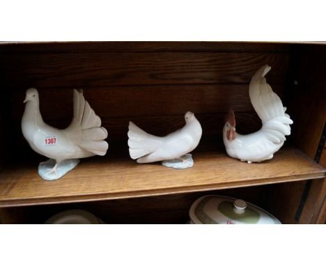 Two Lladro doves and a Lladro chicken.