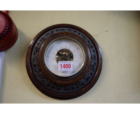An early 20th century oak framed circular aneroid barometer. 