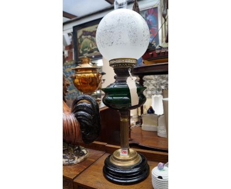 A brass oil lamp, with bottle green glass reservoir. 