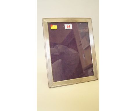 A silver photograph frame, import mark PHV & Co, London 1977, having engine turned and bead decoration, 27 x 21cm. 
