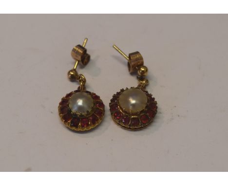 A pair of unmarked ruby and pearl set pendant earrings.