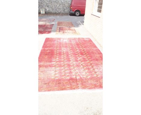 A Cerise ground Bokhara rug having central panel with 95 medallions, 302 x 204cm.