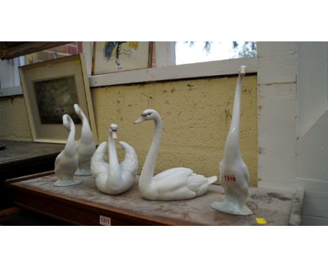 Two Lladro swans; together with three Nao geese.