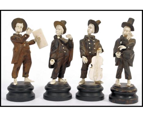 A collection of 4 late 19th century German Black Forest ivory and wooden carved figurines of musicians - band. All raised on 