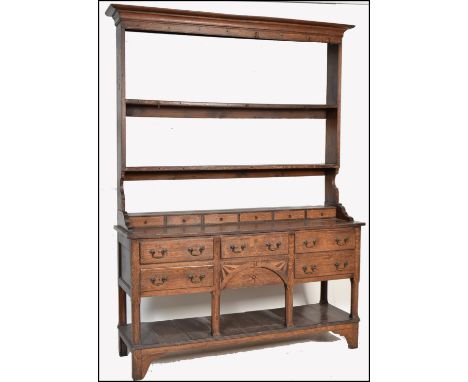 An 18th century George III oak line inlaid dresser. Raised on chamfered edge squared legs with pot shelf uniting. Above a ser