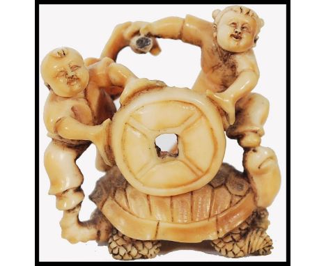 A Japanese Meiji period carved ivory netsuke in the form of a large turtle being ridden by two sailors, one with tiller in ha