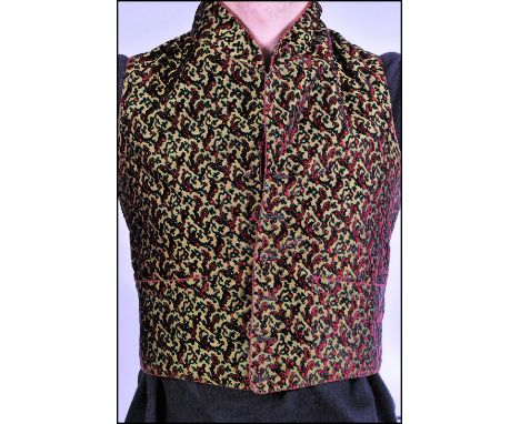 A fantastic 19th century cotton and velvet waistcoat suit jacket having a hand embroidered red design on green and yellow bac