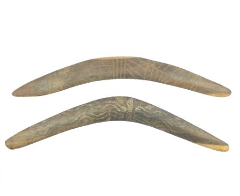 Two Stone Carved Boomerangs, the first 60cm in diameter and decorated with stylised snakes, together with another stone carve