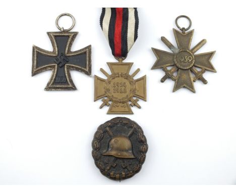 A Third Reich Iron Cross 2nd Class, together with a 2nd Class War Merit Cross with Swords,  a 1914/18 Cross of Honour with Sw