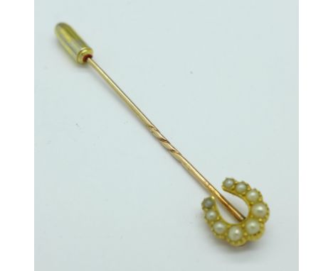 A yellow metal and seed pearl horseshoe stick pin