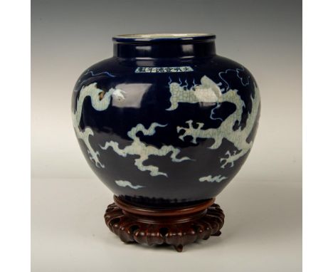 A beautiful navy-blue glazed round shaped pot depicting exposed white craquelure dragons. Chinese inscription the top side. I