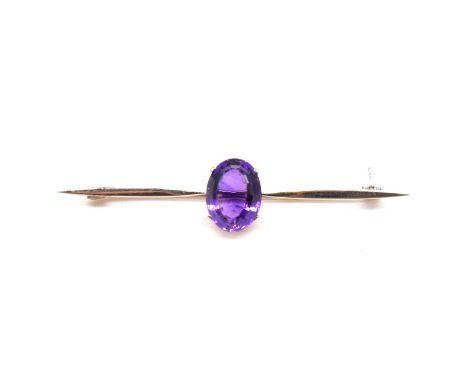 An amethyst bar brooch, the oval step cut stone, 13x10mm, four claw set to centre of a 65mm white metal marked 9ct, gross wei
