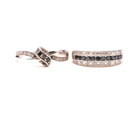 Two black and white diamond rings, a black and white diamond ring, the twelve round brilliant cut black diamonds channel set 