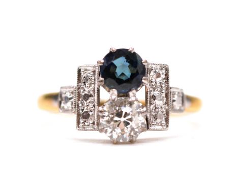 A sapphire and diamond two stone ring, the 5.2mm round brilliant cut sapphire and old cut diamond claw set vertically with a 