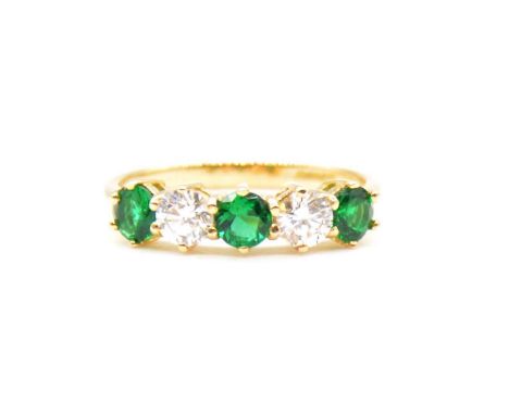 An emerald and diamond half hoop ring, three circular faceted emeralds and two brilliant cut diamonds claw claw set in an 18 