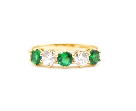 An emerald and diamond half hoop ring, three circular faceted emeralds and two brilliant cut diamonds claw claw set in an 18 