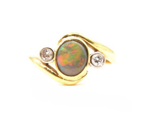 A natural black opal and diamond dress ring, an oval cabochon cut opal 7.2x6.2mm, collet set in an 18 carat yellow gold hand 