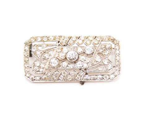 An Art Deco diamond brooch, three major old cut diamonds collet set on the diagonal to a white metal rectangular brooch with 