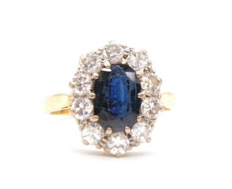 A sapphire and diamond oval cluster ring, the oval mixed cut sapphire, 9.5 x 7mm claw set and surrounded by ten brilliant cut