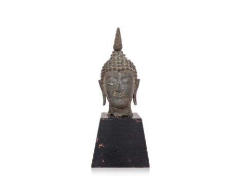 A THAI BRONZE HEAD OF BUDDHA ON WOOD STAND
Cast bronze, with curled hair, flame finial and elongated ears, on ebonised wood s