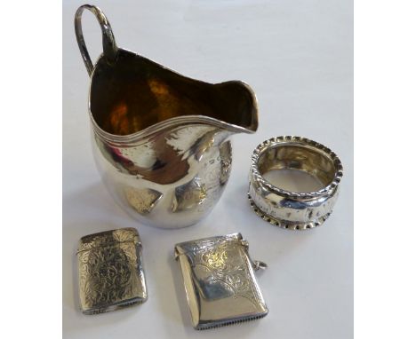 A George III silver bright cut cream jug London 1795, two silver vesta cases and a napkin ring (4)