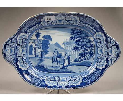 A BLUE PRINTED EARTHENWARE SOUP TUREEN - STAND WITH PRINTS OF FIGURES BETWEEN A CLASSICAL TEMPLE AND SUNDIAL, 44CM OVER HANDL
