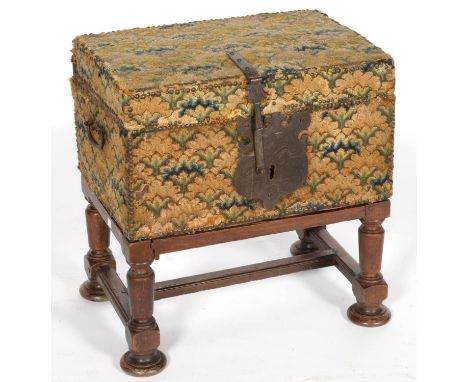 A CONTINENTAL BOARDED WOOD TRUNK COVERED IN CONTEMPORARY BRASS NAILED WOOLWORK, IRON HINGES, CARTOUCHE SHAPED LOCK PLATE, ENG