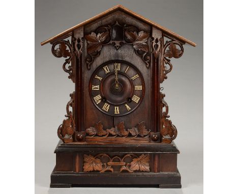 A GERMAN ARCHITECTURAL STAINED WOOD CUCKOO CLOCK, THE CASE APPLIED WITH LEAFAGE, BRASS HAND, GONG STRIKING MOVEMENT WITH TWO 