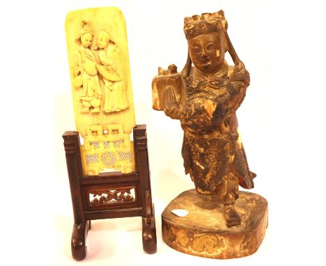 19th century carved and lacquered softwood figure, H: 15 cm and a carved and reticulated ivory panel on stand, depicting two 