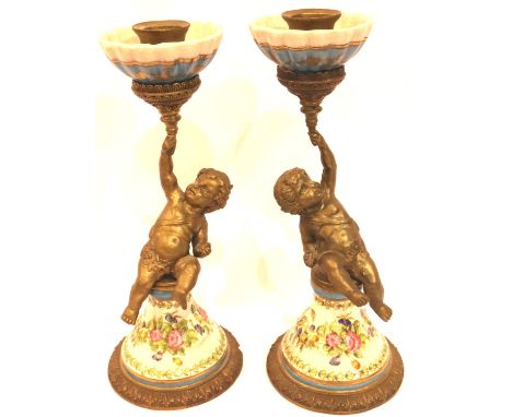 Pair of gilt metal and ceramic garnitures in the form of putti holding torches, each H: 25 cm. P&amp;P Group 3 (£25+VAT for t