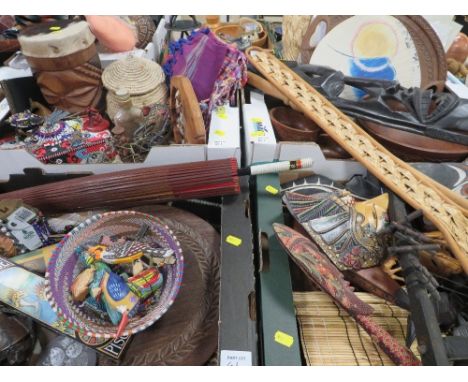 Four trays of assorted tourist items to include Arican tribal items, bead work, Oriental umbrella, textiles etc