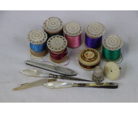 Mother-of-pearl topped bobbin holders, mother-of-pearl handled sewing tools, white metal thimble and a small  tape measure